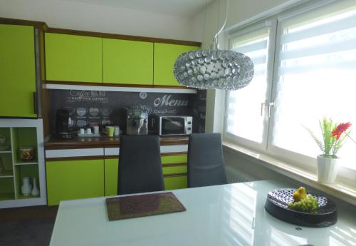 a kitchen with green cabinets and a table with a bowl of fruit at Rubin in Sinsheim