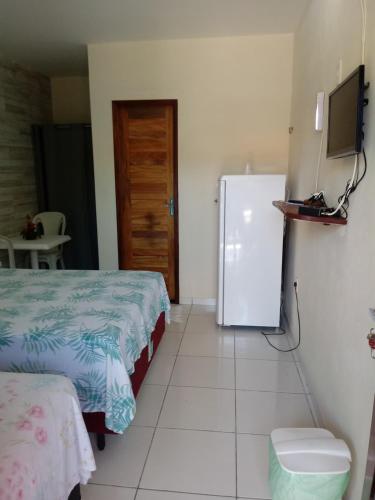a room with two beds and a refrigerator at Pousada Chalé Mar Rio in Galinhos