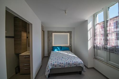 Un dormitorio con una cama con almohadas azules y una ventana en Du Large, en Bayona
