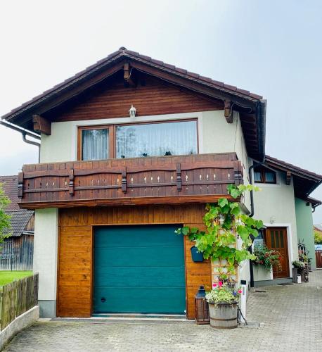 une maison avec un garage et un balcon au-dessus dans l'établissement Haus Polleruhs, à Aflenz Kurort