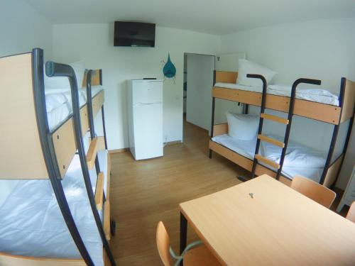 a dorm room with bunk beds and a table and a desk at Hostel & Monteurzimmer bei Hansezimmer in Hamburg