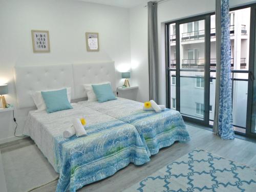 um quarto com uma cama grande e almofadas azuis em Town Apartment no Funchal