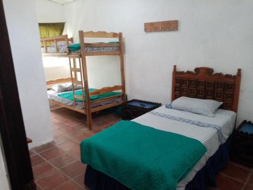 El TamarindoにあるLa Ceja Beach Houseのベッド2台と二段ベッド1組が備わる客室です。