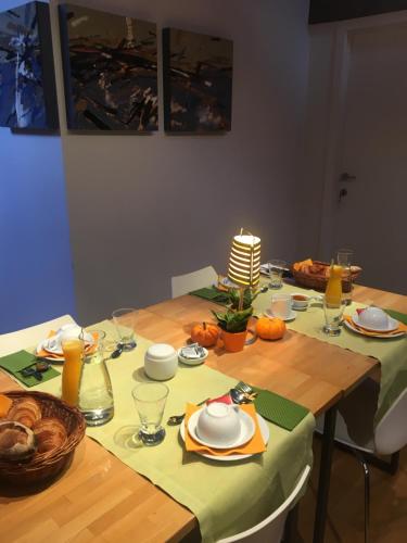 a dining room table with a green table cloth and a candle at B&B Setola in Bruges