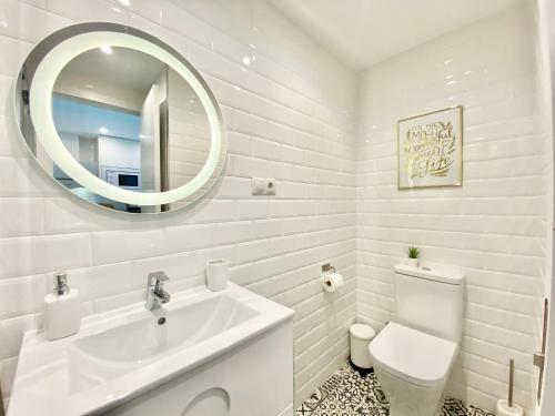 ein weißes Badezimmer mit einem Waschbecken und einem Spiegel in der Unterkunft New Studio Júpiter Benalmádena Pools Views in Benalmádena