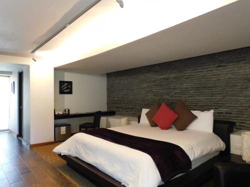 アトリスコにあるHotel & Spa Luna Canela Boutiqueのレンガの壁のベッドルーム1室(大型ベッド1台付)