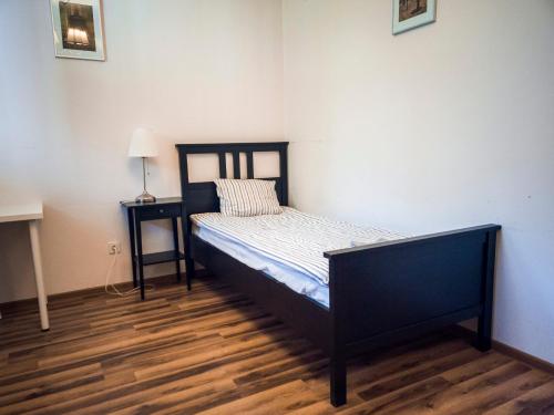 ナウェンチュフにあるApartamenty Nałęczowskieの小さなベッドルーム(ベッド1台、ナイトスタンド付)