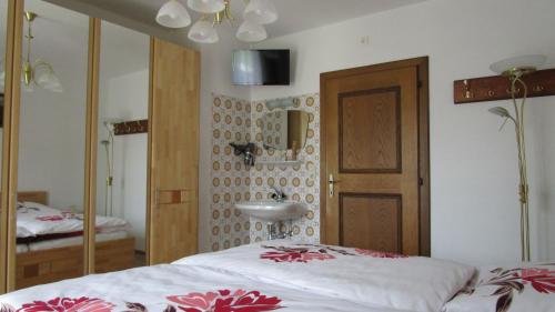 a bedroom with a bed and a sink and a mirror at Ferienhaus Englbrecht in Krispl