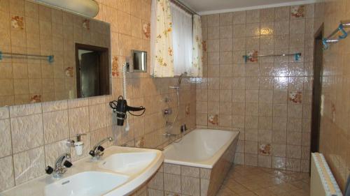 a bathroom with a tub and a sink and a mirror at Ferienhaus Englbrecht in Krispl