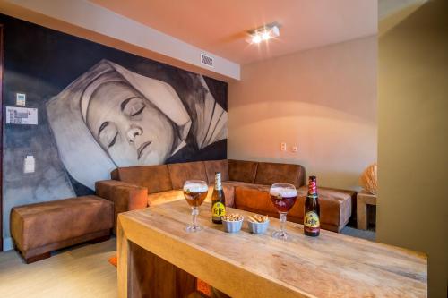 a large painting of a woman with glasses of wine at La Merveilleuse by Infiniti hôtel in Dinant
