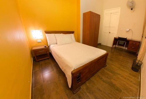 a bedroom with a bed and a yellow wall at 61Prado Hotel in Medellín
