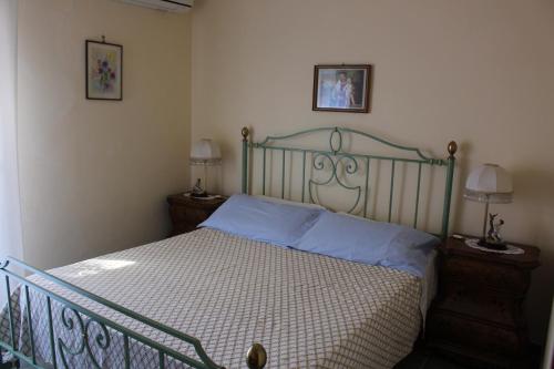 a bedroom with a bed with blue pillows on it at CASA AL MARE A SCOPELLO in Scopello