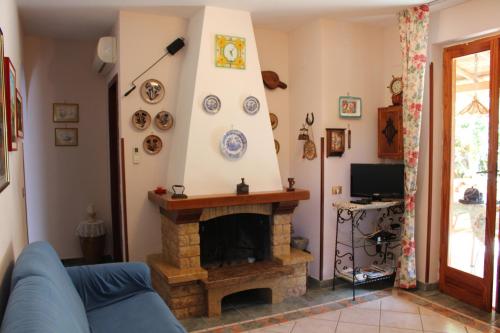a living room with a blue couch and a fireplace at CASA AL MARE A SCOPELLO in Scopello