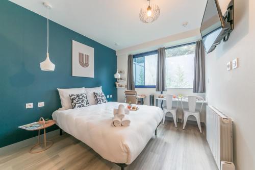 a bedroom with a large white bed and a table at WS Tour Eiffel - Nicolo in Paris