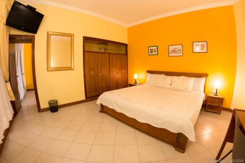 a bedroom with a bed and a flat screen tv at 61Prado Hotel in Medellín