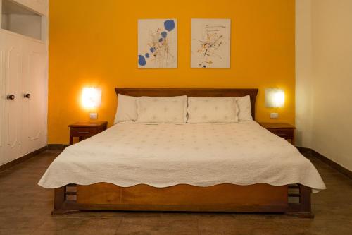 a bedroom with a large bed with two night stands at 61Prado Hotel in Medellín
