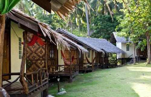 a row of houses with thatched roofs at Shiralea Backpackers Resort in Haad Yao