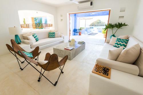 sala de estar con sofá blanco y sillas en Casa Azul & Casa Carioca in Careyes, en Careyes