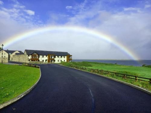 a rainbow over a house and a road with a house at Murrisk Apartments - Self Catering in Westport
