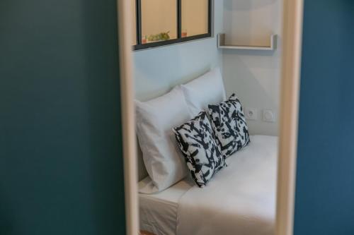 a mirror with a white couch with a pillow on it at WS Tour Eiffel - Nicolo in Paris