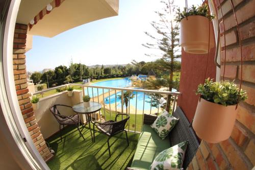 a balcony with a table and chairs and a pool at New Studio Júpiter Benalmádena Pools Views in Benalmádena
