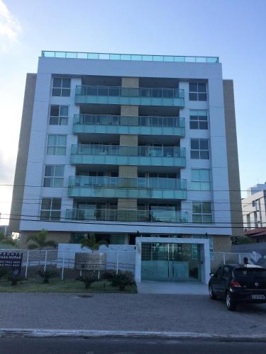 ein großes Gebäude mit einem davor geparkt in der Unterkunft Alugo Apartamento para Contrato ANUAL, praia do Bessa, 2 quartos in João Pessoa