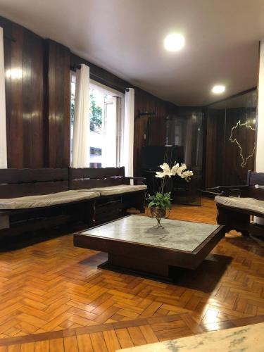 a living room with a table in the middle of a room at Brasil Palace Hotel in Belo Horizonte