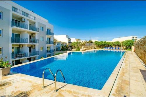 a large swimming pool in front of a building at Hillock Residence Gozo Marsalforn in Marsalforn