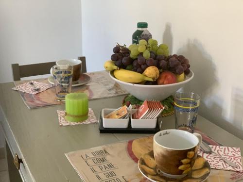 a table with a bowl of grapes and a bowl of fruit at Garden Hill BnB in Broni