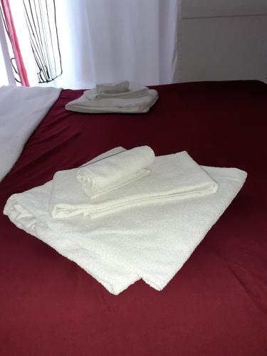 zwei weiße Handtücher auf dem Bett in der Unterkunft Piccola Montmartre a Torino in Turin