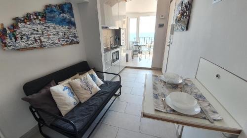 uma sala de estar com um sofá e uma mesa de vidro em Best flat beachfront Camogli em Camogli