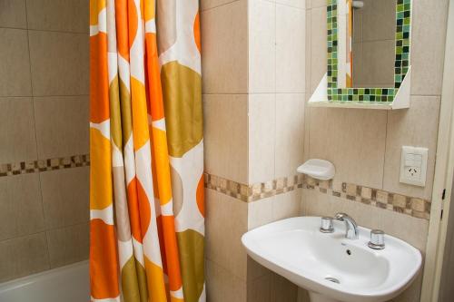 a bathroom with a sink and a shower curtain at DEPARTAMENTO CON EXCELENTE UBICACIÓN in San Carlos de Bariloche