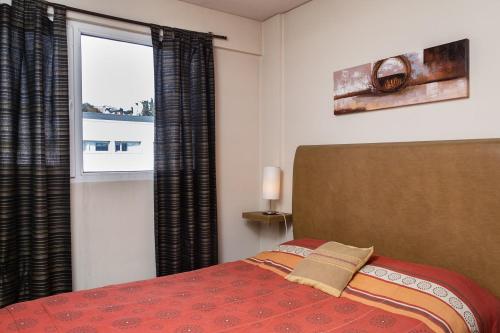 Schlafzimmer mit einem Bett und einem Fenster in der Unterkunft DEPARTAMENTO CON EXCELENTE UBICACIÓN in San Carlos de Bariloche