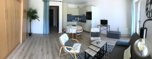 un soggiorno con divano e sedie e una cucina di Grand studio Clémenceau Vue mer 3 étoiles a Pléneuf-Val-André