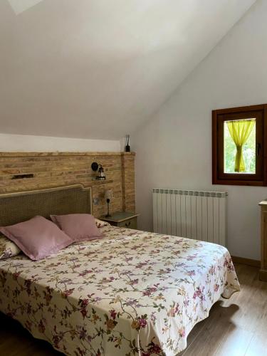 a bedroom with a bed and a window at Hoz de Jaca, Casa Mas Mañanas. in Hoz de Jaca