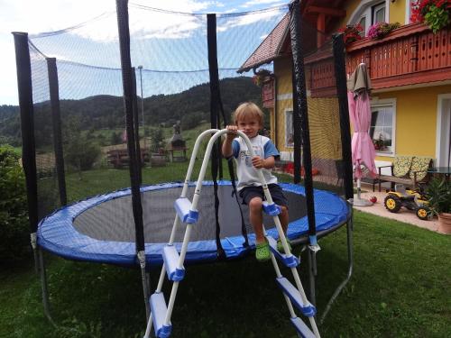 a young boy riding on a trampoline at Apartments and Rooms With View on Bled in Bled