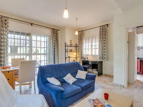 a living room with a blue couch and a table at Belvilla by OYO Casa de Rudi in Seville