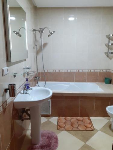 une salle de bain avec une baignoire et un lavabo dans l'établissement Residence La corniche Étage 4, à Nador