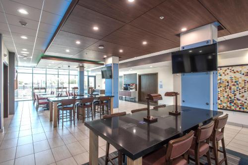 a restaurant with a bar and some tables and chairs at Holiday Inn Express & Suites - Phoenix North - Happy Valley by IHG in Phoenix