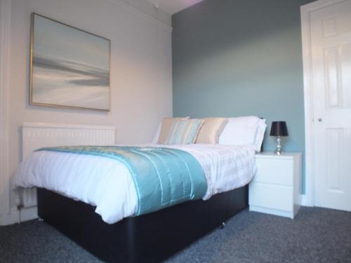een slaapkamer met een bed met een foto aan de muur bij Stamford Place by SG Property Group in Crewe