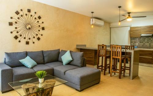 a living room with a couch and a table and a kitchen at Albra Tulum in Tulum