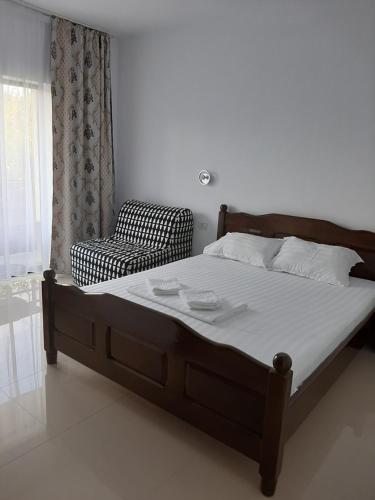 1 dormitorio con 1 cama grande y 1 silla en ROMSIL CASA VACANTA, en Costinesti