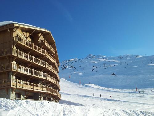 a large building on a ski slope in the snow at CGH Résidences & Spas les Chalets du Soleil Contemporain in Les Menuires