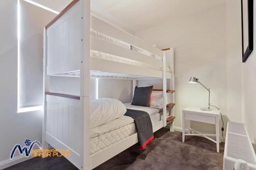 a white bunk bed in a room with a desk at Zoncolan in Dinner Plain