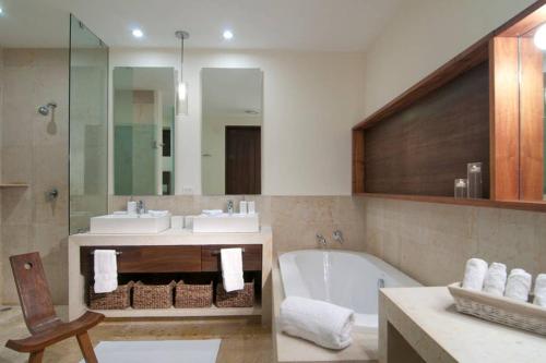 a bathroom with a tub and two sinks and a bath tub at Spectacular Beachfront at veneros fully staffed in Cruz de Huanacaxtle