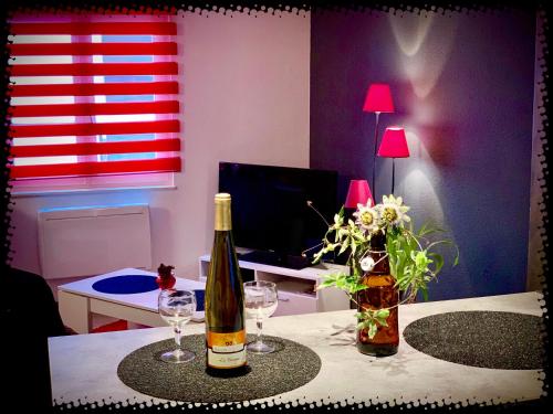 2 bouteilles de vin et 2 verres sur une table dans l'établissement Résidence des lentilles, à Schiltigheim