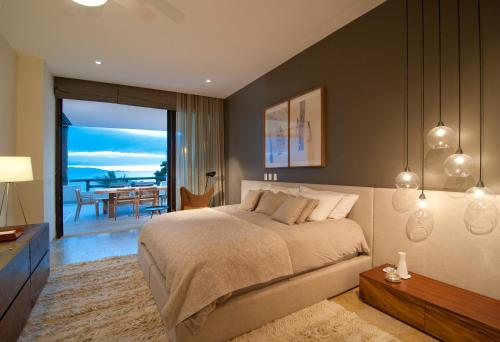 a bedroom with a bed and a view of the ocean at Spectacular Beachfront at veneros fully staffed in Cruz de Huanacaxtle