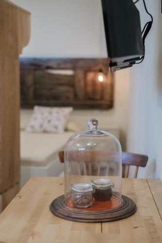 a glass jar with two candles in it on a table at BABhouse Garagem do Adro - Coração do Douro in Nagoselo do Douro