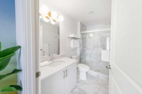 a white bathroom with a sink and a toilet at The Laundry Rooms - Waterloo in Waterloo