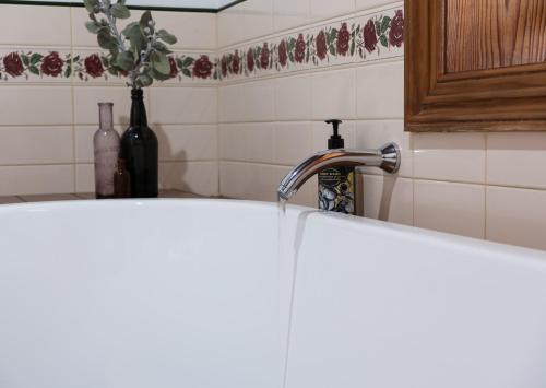 a kitchen sink with water pouring from a kitchen faucet at Merrijig Inn in Port Fairy